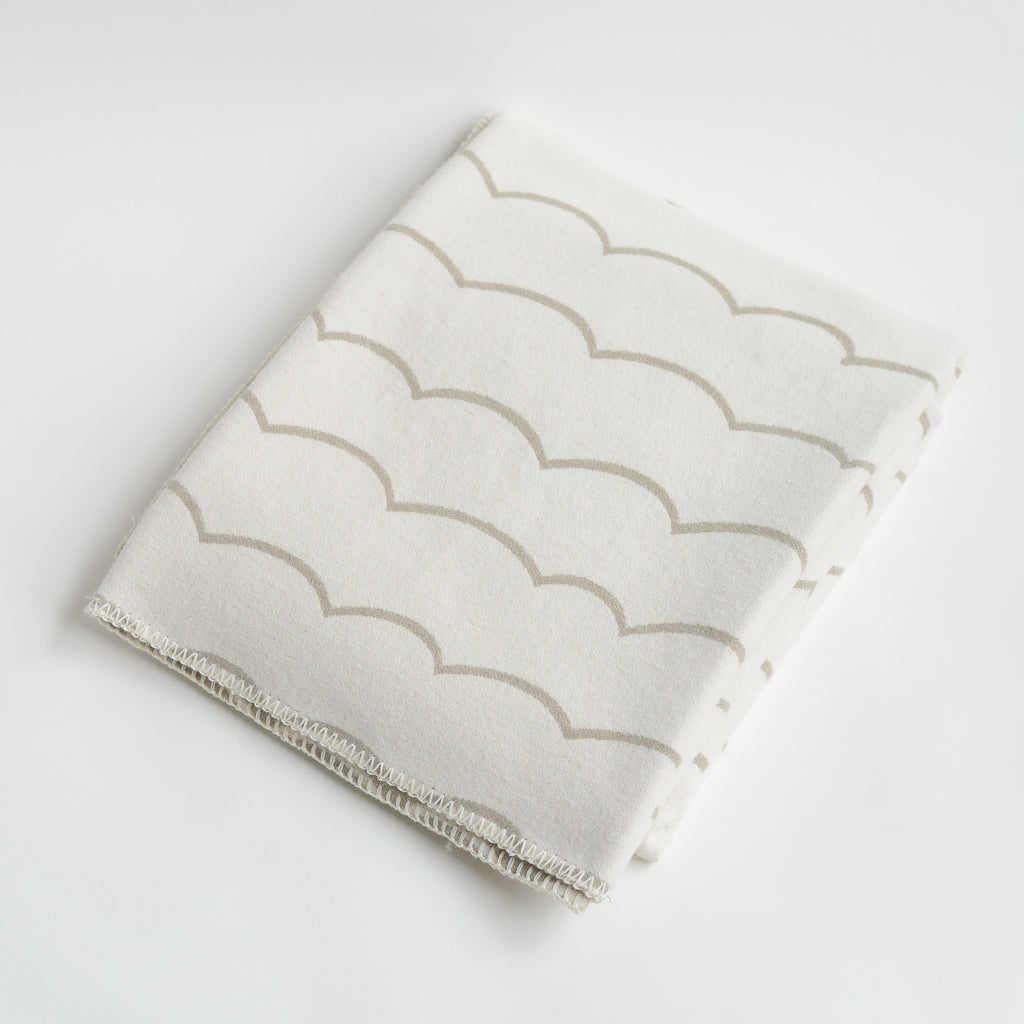 Our 100% cotton Wave throw is the perfect accent to any room. Woven by our experts using traditional techniques, each cotton blanket is lightweight, breathable and soft to touch.&nbsp;Designed by our in house design team the simplistic wave lines bring a geometric style to a classic throw. It's reversible with a soft vintage beige to one side and subtle cream on the reverse. Then finished with cream blanket stitch detailing.